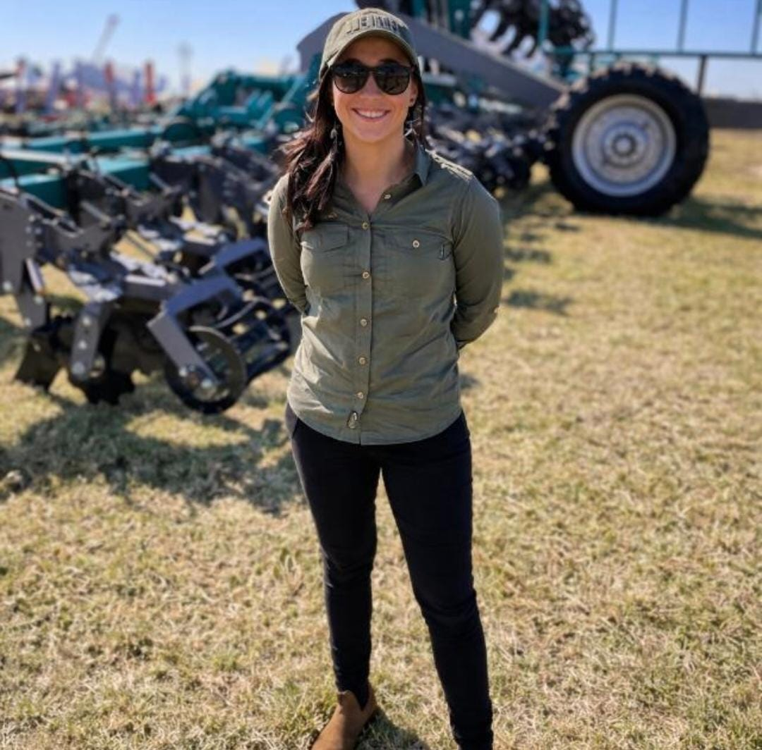 Simone Pelser, founder of Safe Roots Consulting, beside agricultural equipment